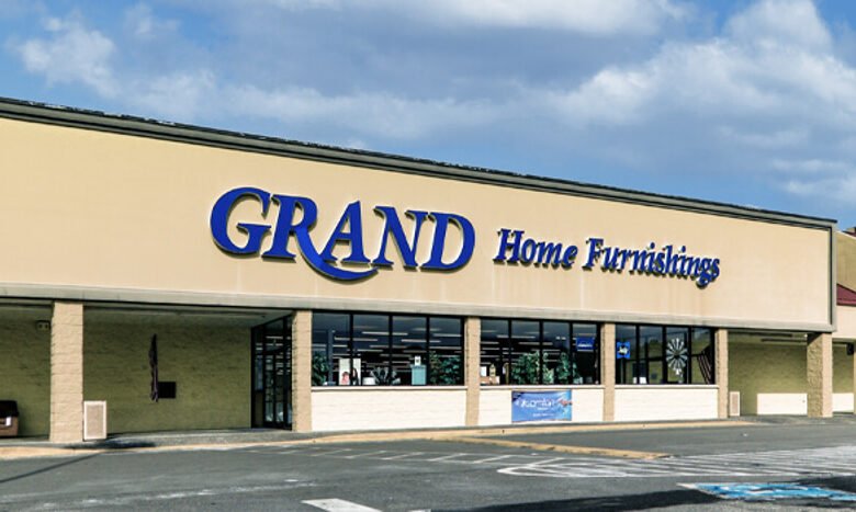 alt="Grand Home Furnishings store exterior with large sign and parking lot"